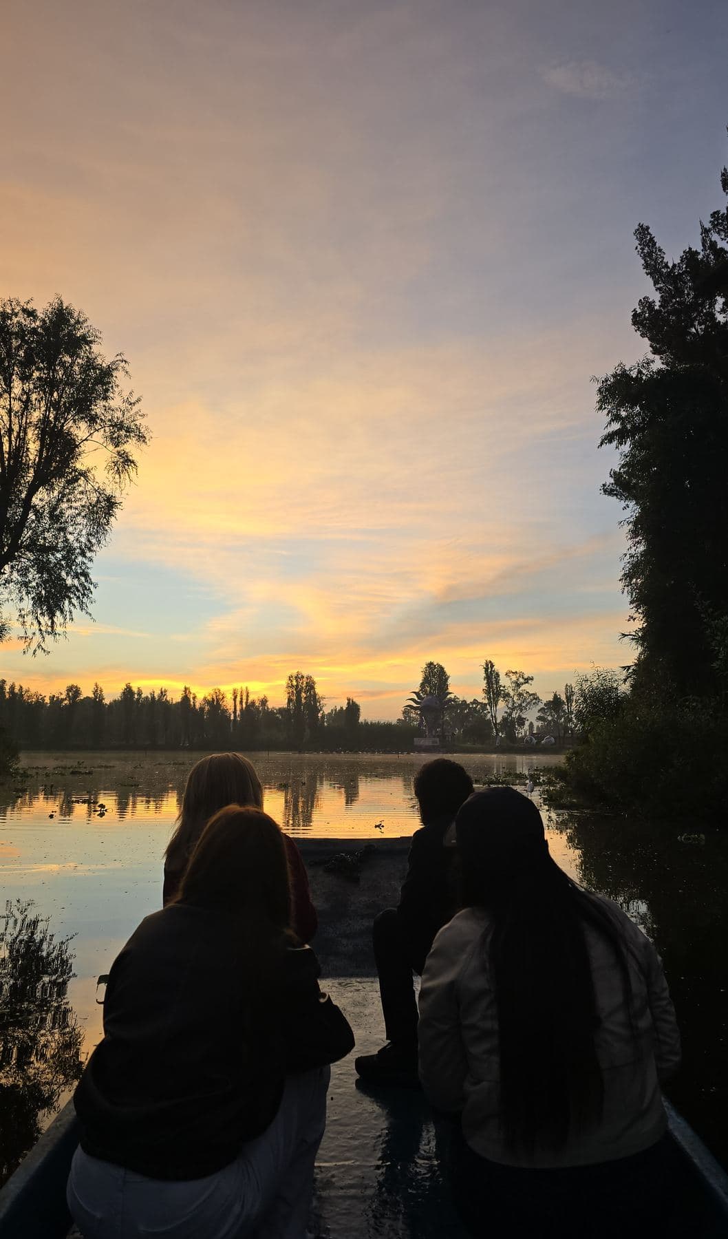 Dos personas contemplan el amanecer junto al agua