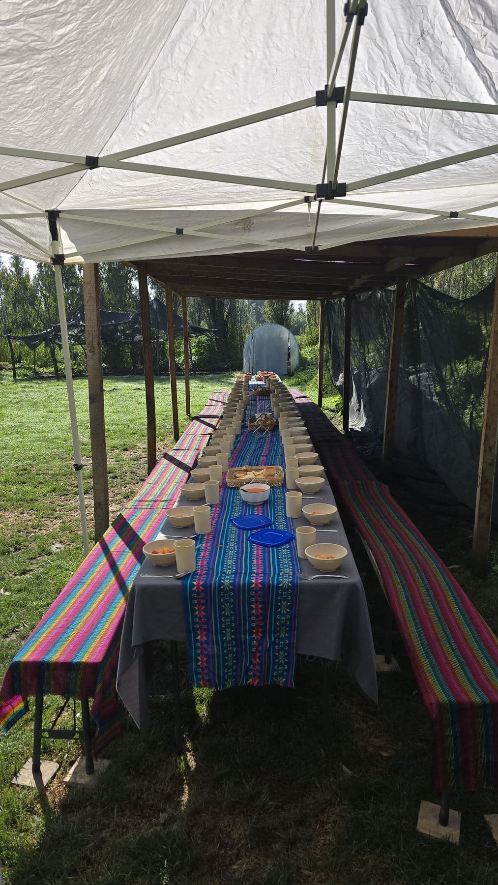 Mesa larga bajo una carpa en la chinampa