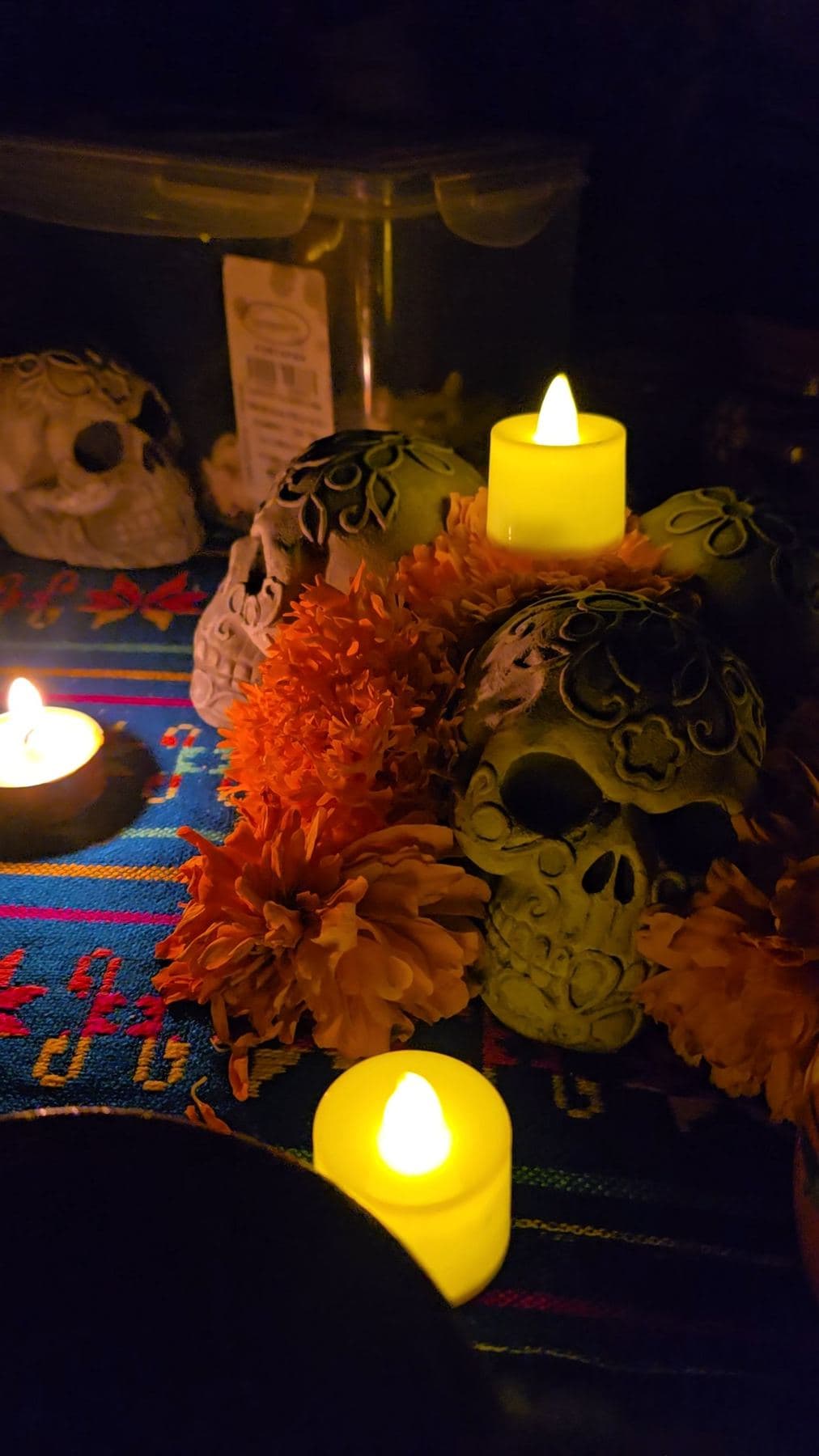 Ofrenda con velas, calaveras y flores de cempasúchil