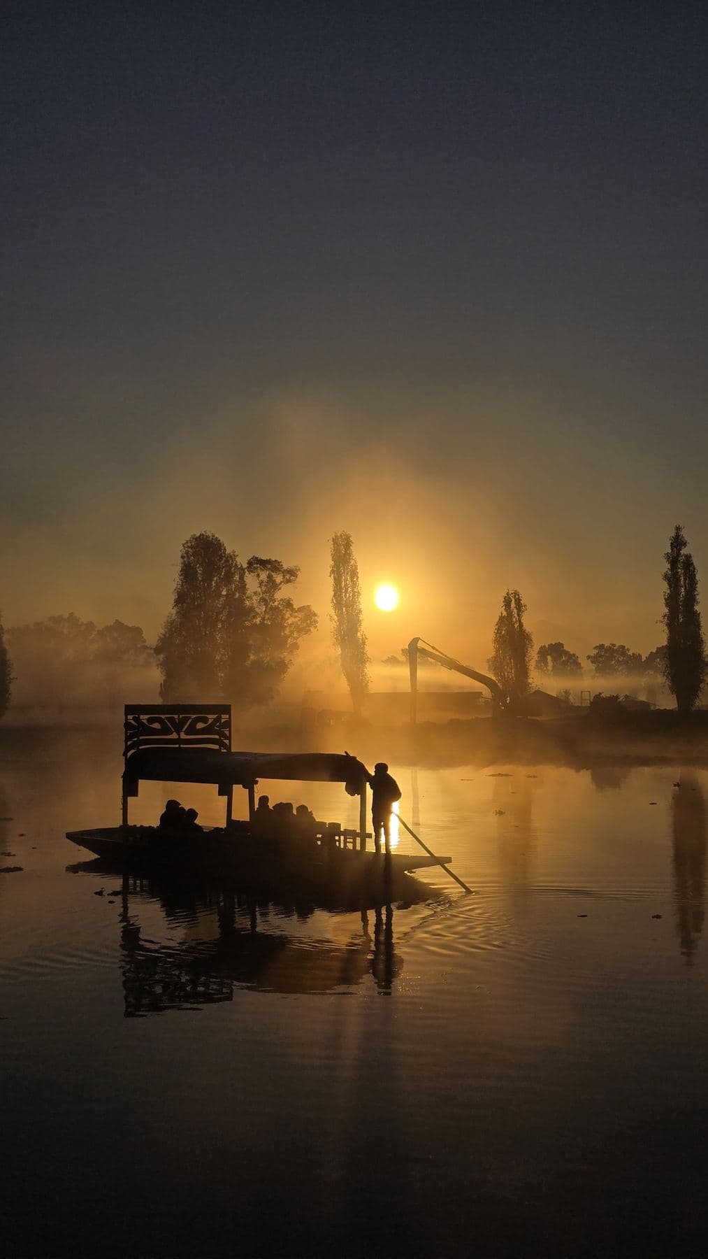 Embarcación a contraluz en la niebla del amanecer