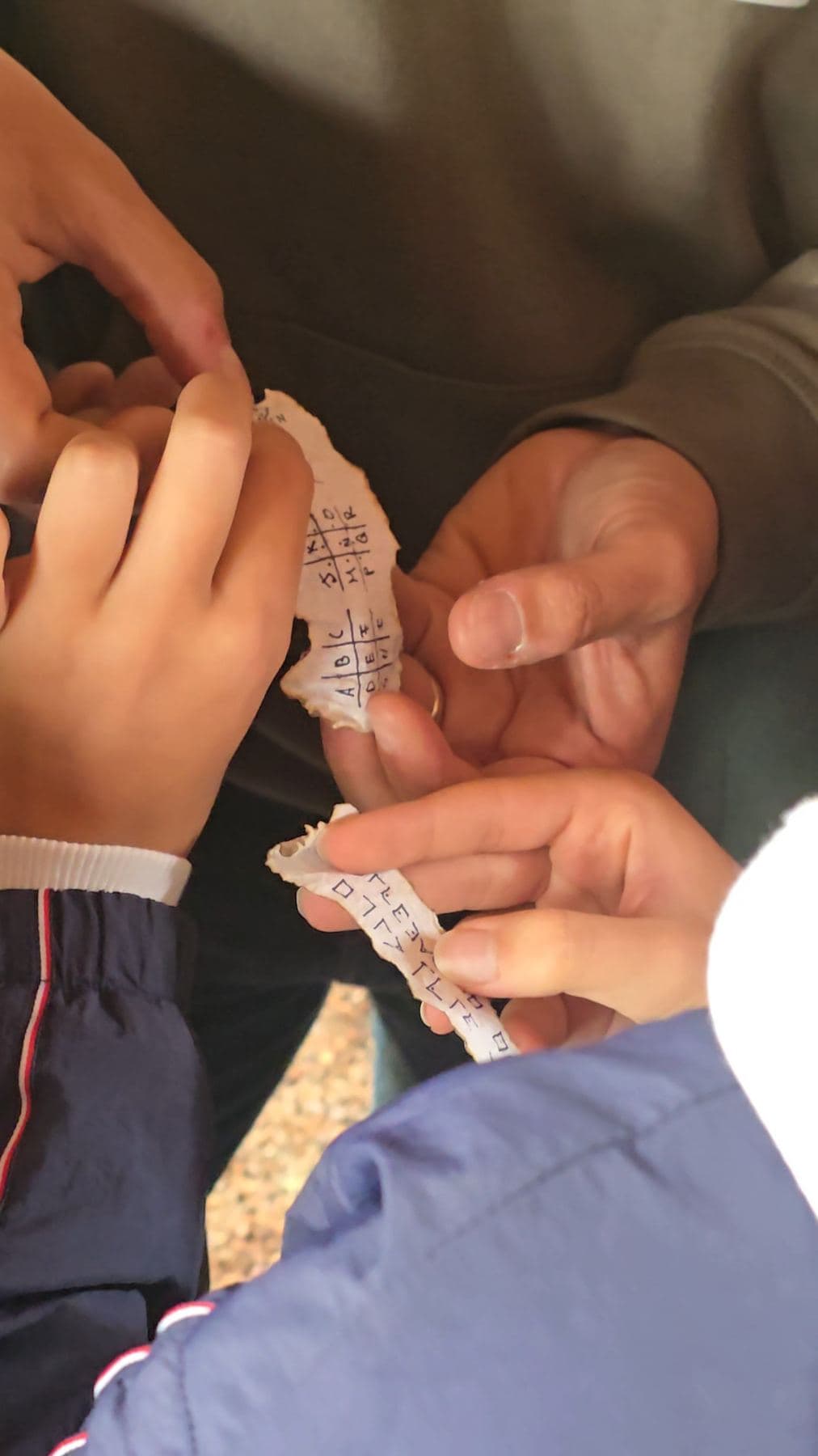 Manos sostienen una pista de papel durante la búsqueda del tesoro